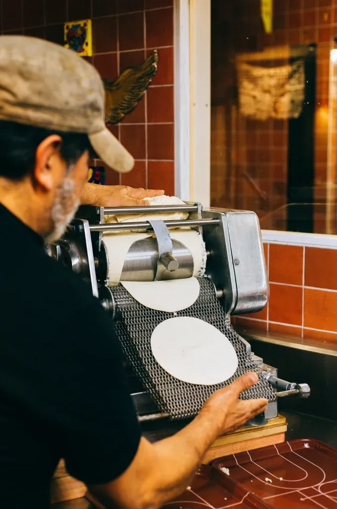 Fresh corn tortillas being pressed